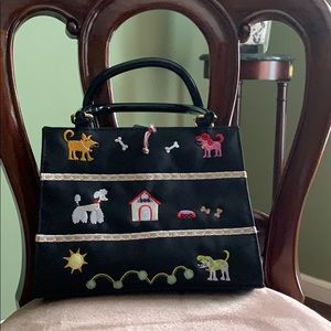 Black purse with dogs and embroidered on it